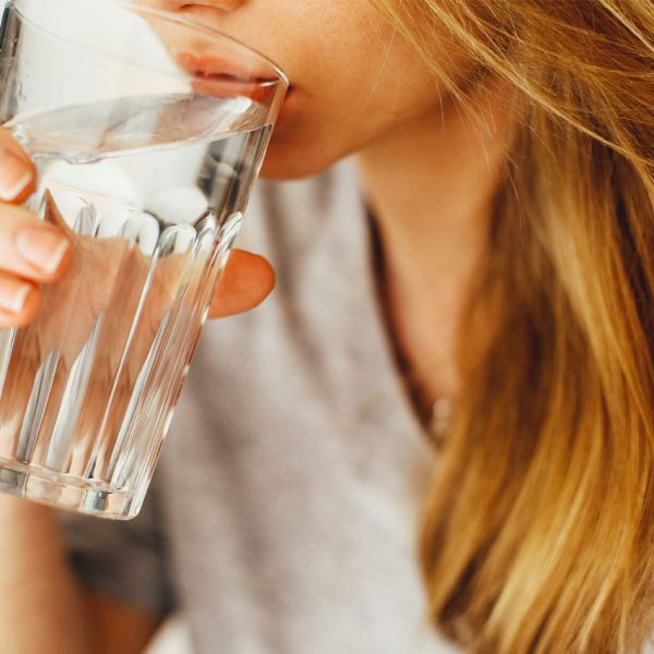 Nainen juo vettä lasista