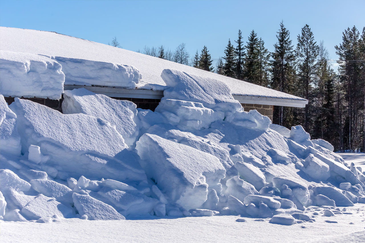 Valtava lumimäärä on tippunut ulkorakennuksen katolta.